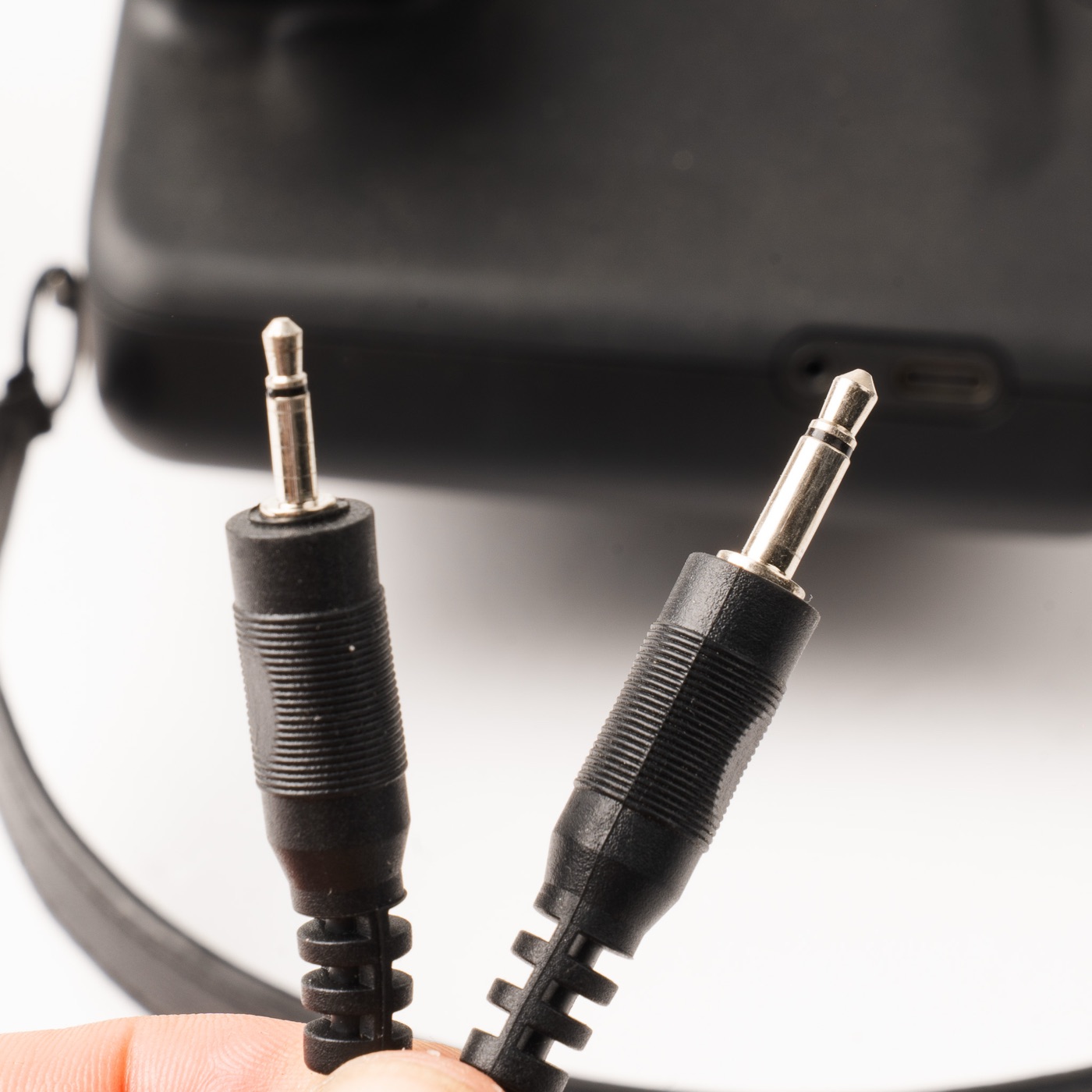Close-up of the two-ended flash sync cable: 2.5 mm plug on the left, 3.5 mm on the right