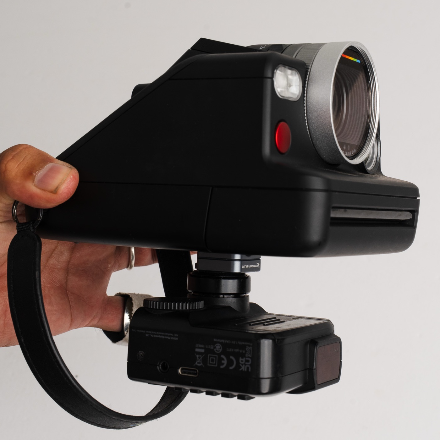 Godox X2T trigger mounted on a bracket under the Polaroid I-2 with the sync cable connected