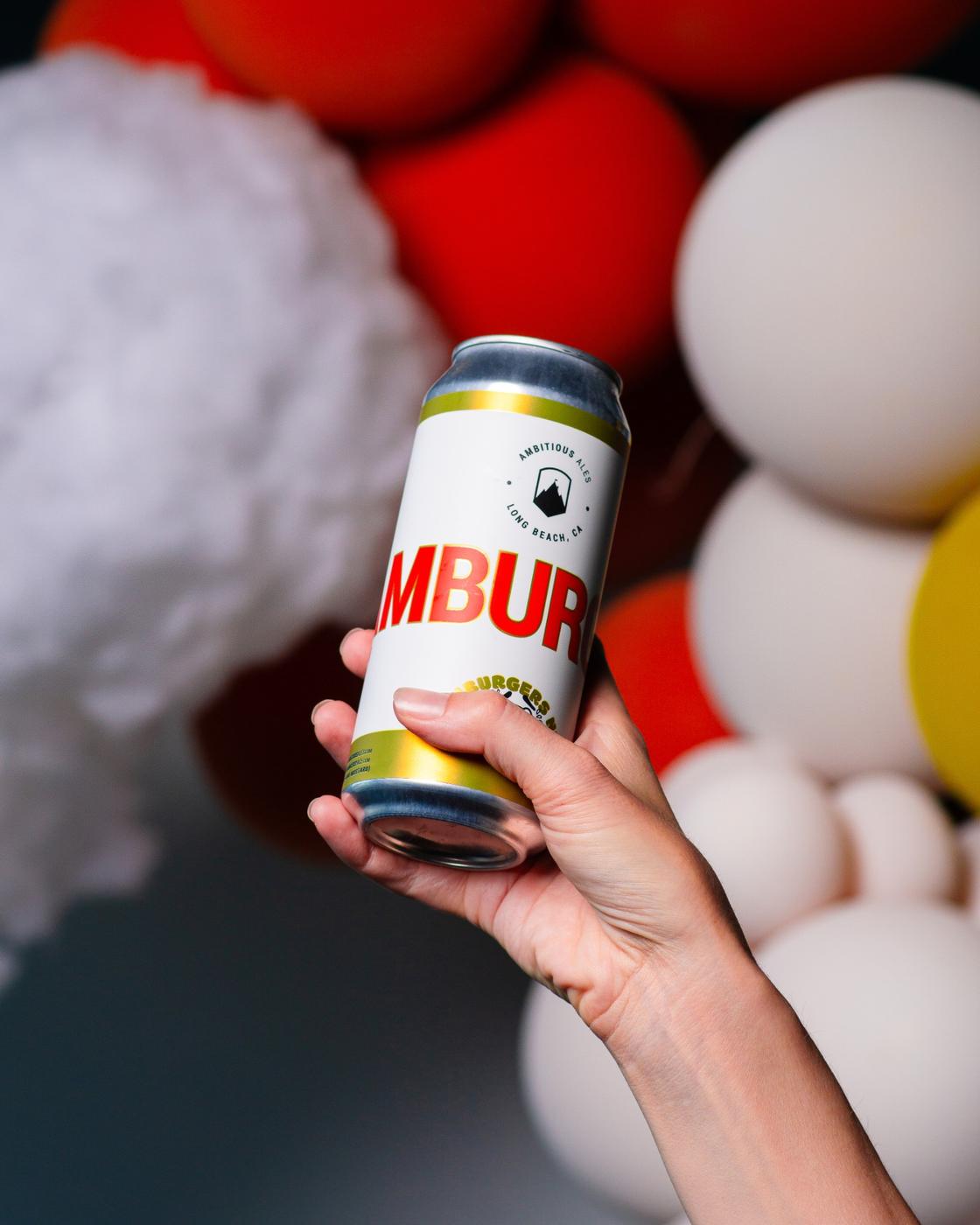 Hand holding a beer can in front of a balloon wall