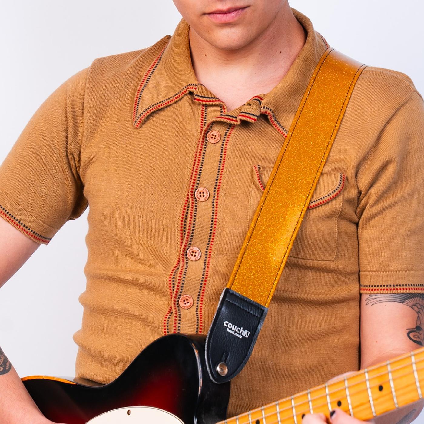 Model in an orange knit polo with a gold sparkle strap